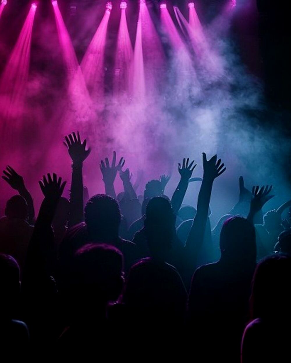 A packed Lawrence late-night dance floor washed in pink and cyan stage lights