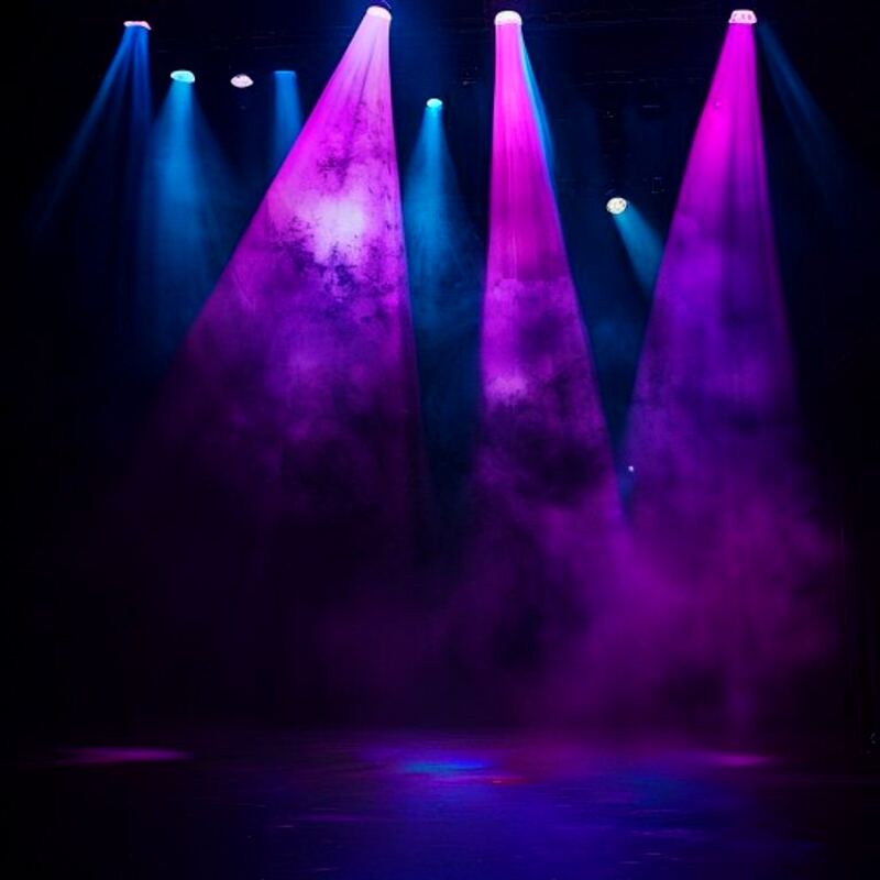 Stage spotlights cutting through haze in purple and blue